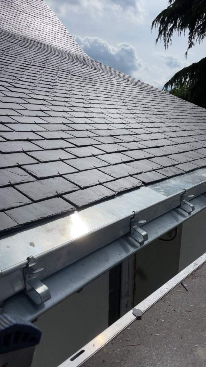 Ttoiture en ardoise avec des gouttières en zinc récemment installées Mésanger